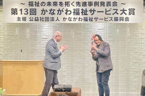 「つながり賞」を受賞し、トロフィーを掲げる三休合同会社 世古口敦嗣さん（右）